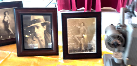 Framed 1920s portraits beside a vintage movie projector
